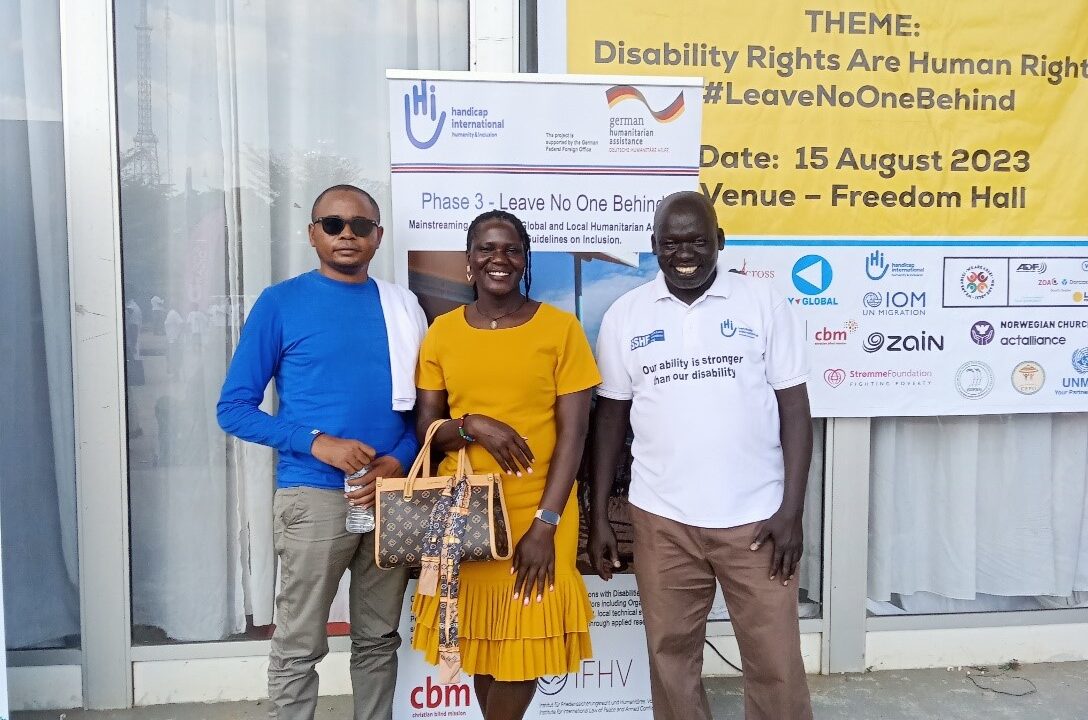 HI representatives posing in front of the Leave no one behind! project roll-up a the UNCRPD launch in South Sudan.