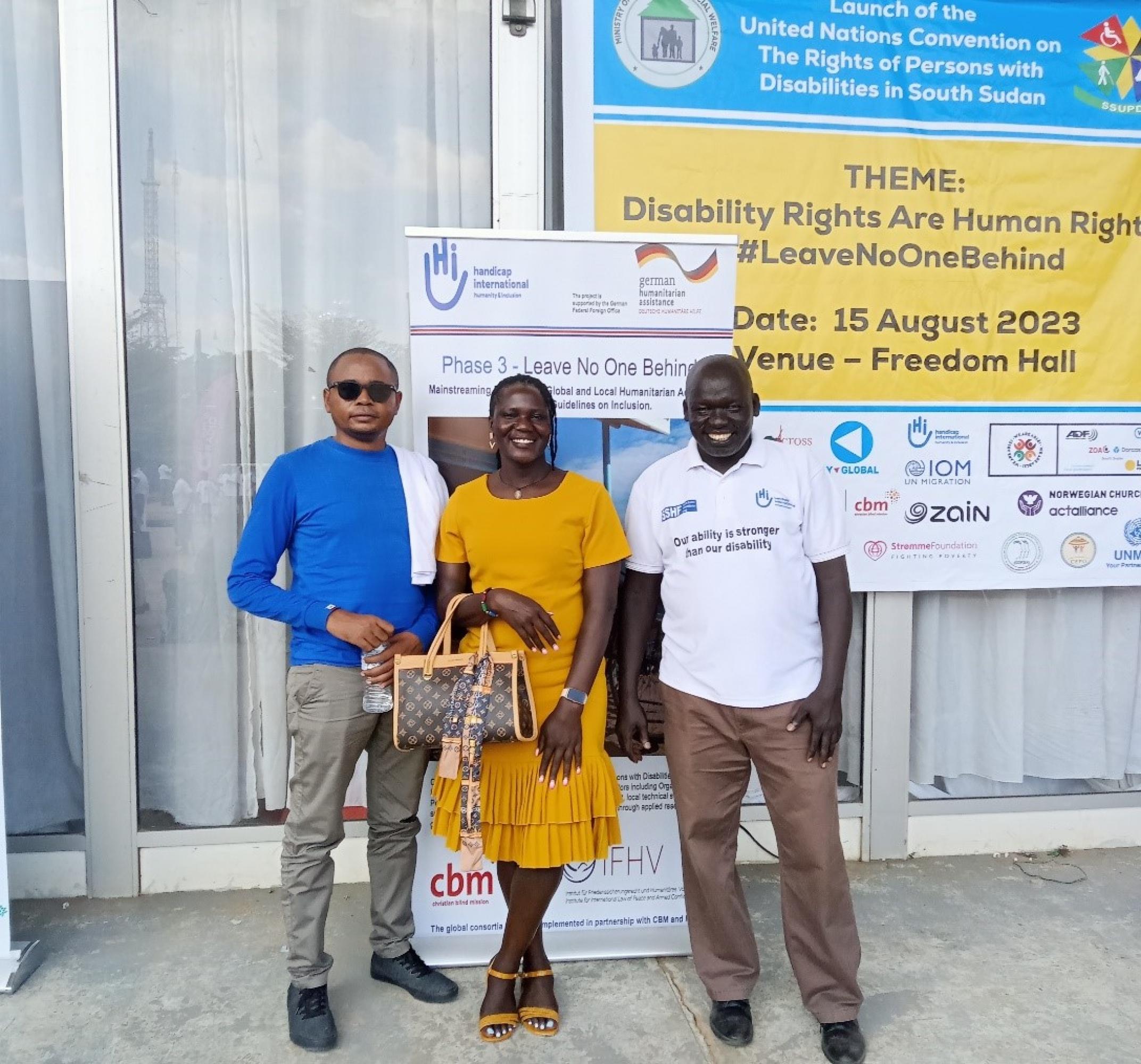 HI representatives posing in front of the Leave no one behind! project roll-up a the UNCRPD launch in South Sudan.