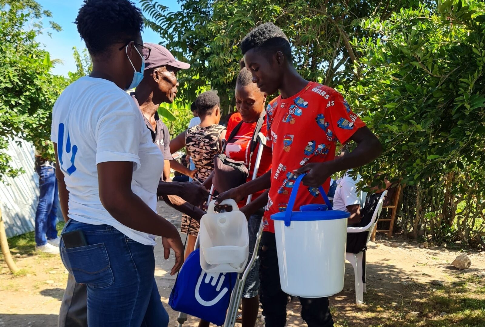 Woman distributing hygiene kits to persons.