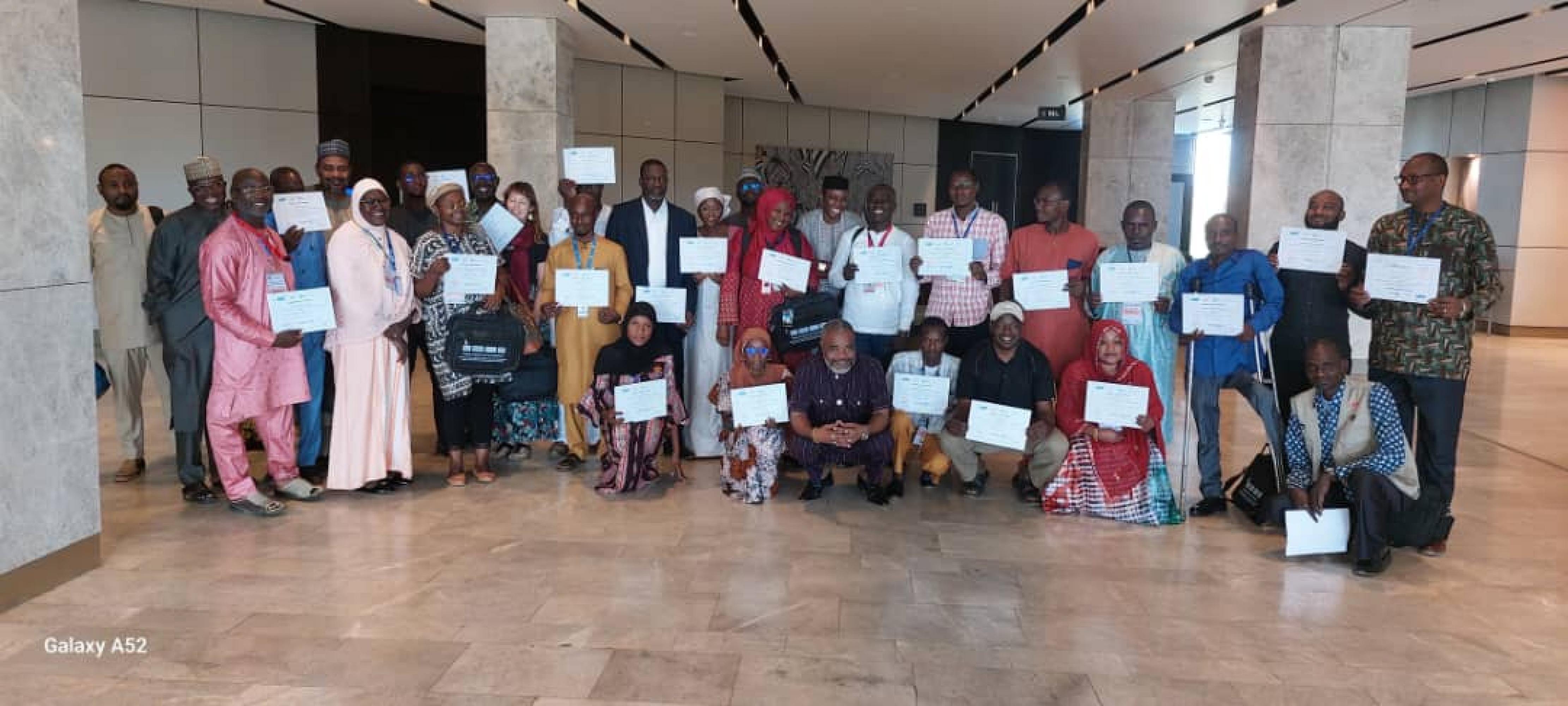 Group of training participants posing to the camera certificates in their hand.