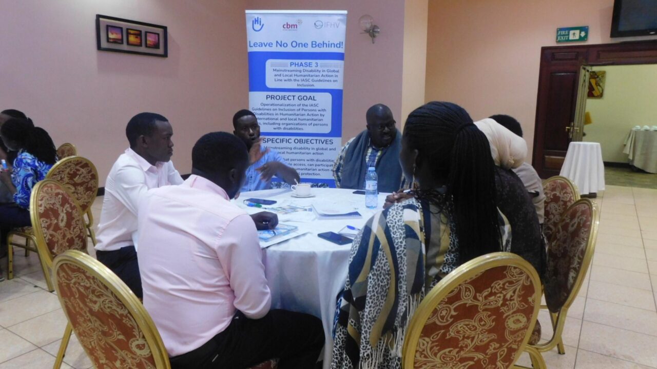Group of workshop participants sitting around a table and having a group discussion.