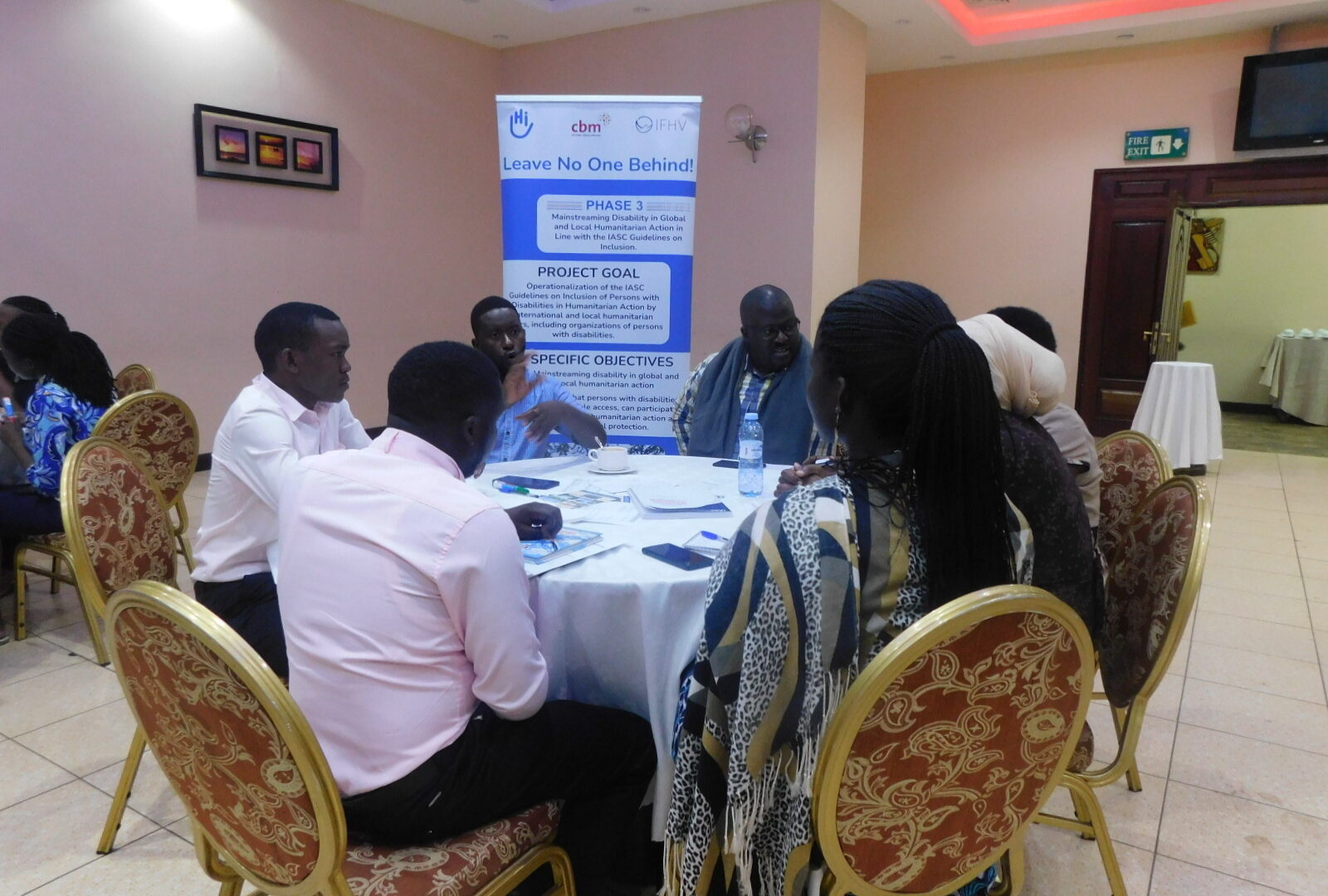 Group of workshop participants sitting around a table and having a group discussion.