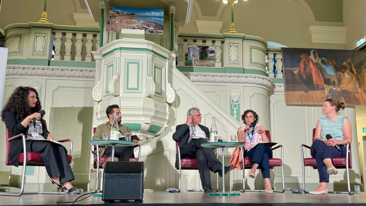 Panel-Diskussion mit Moderatorin und vier Teilnehmenden.