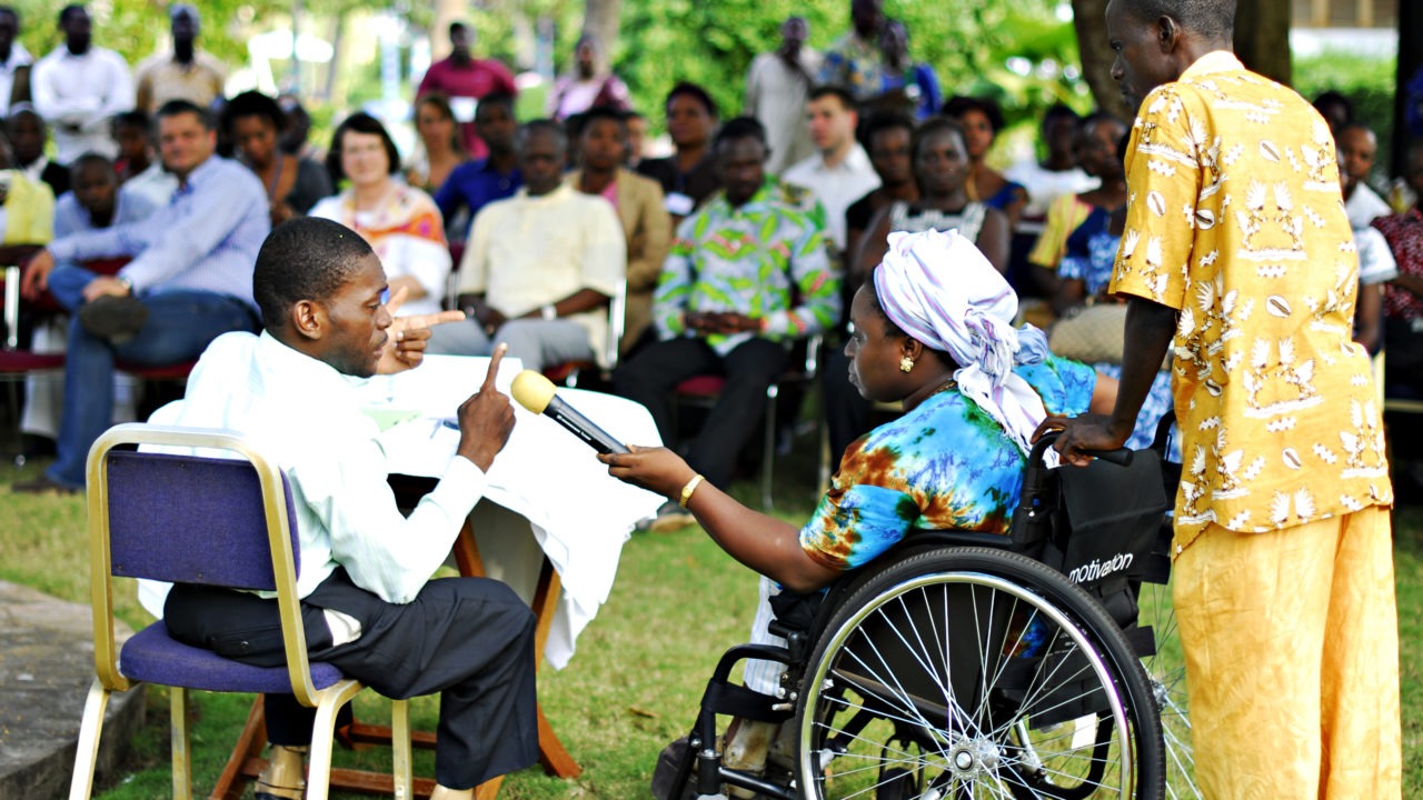 Women in a wheelchair holding the microphone to another person