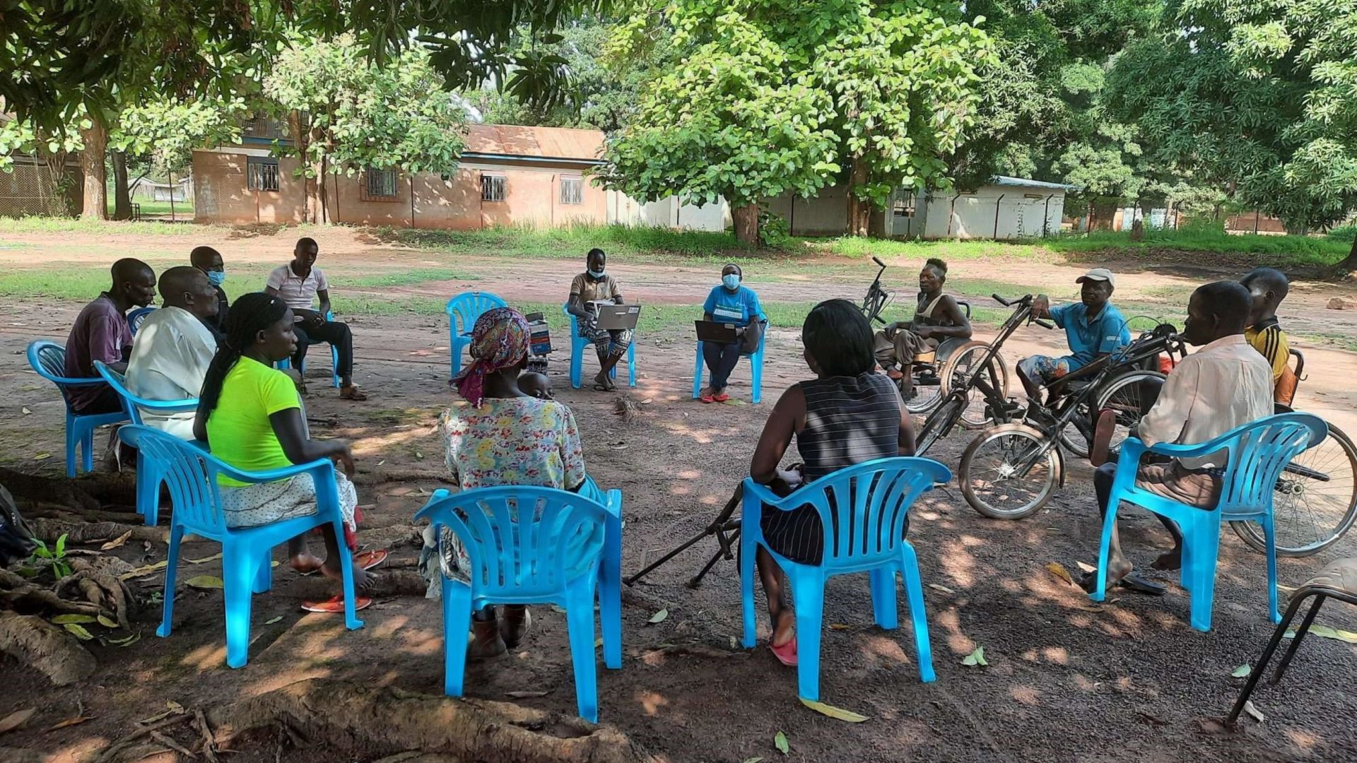 Cover photo of the South Sudan field report. Shows a group of people sitting together.