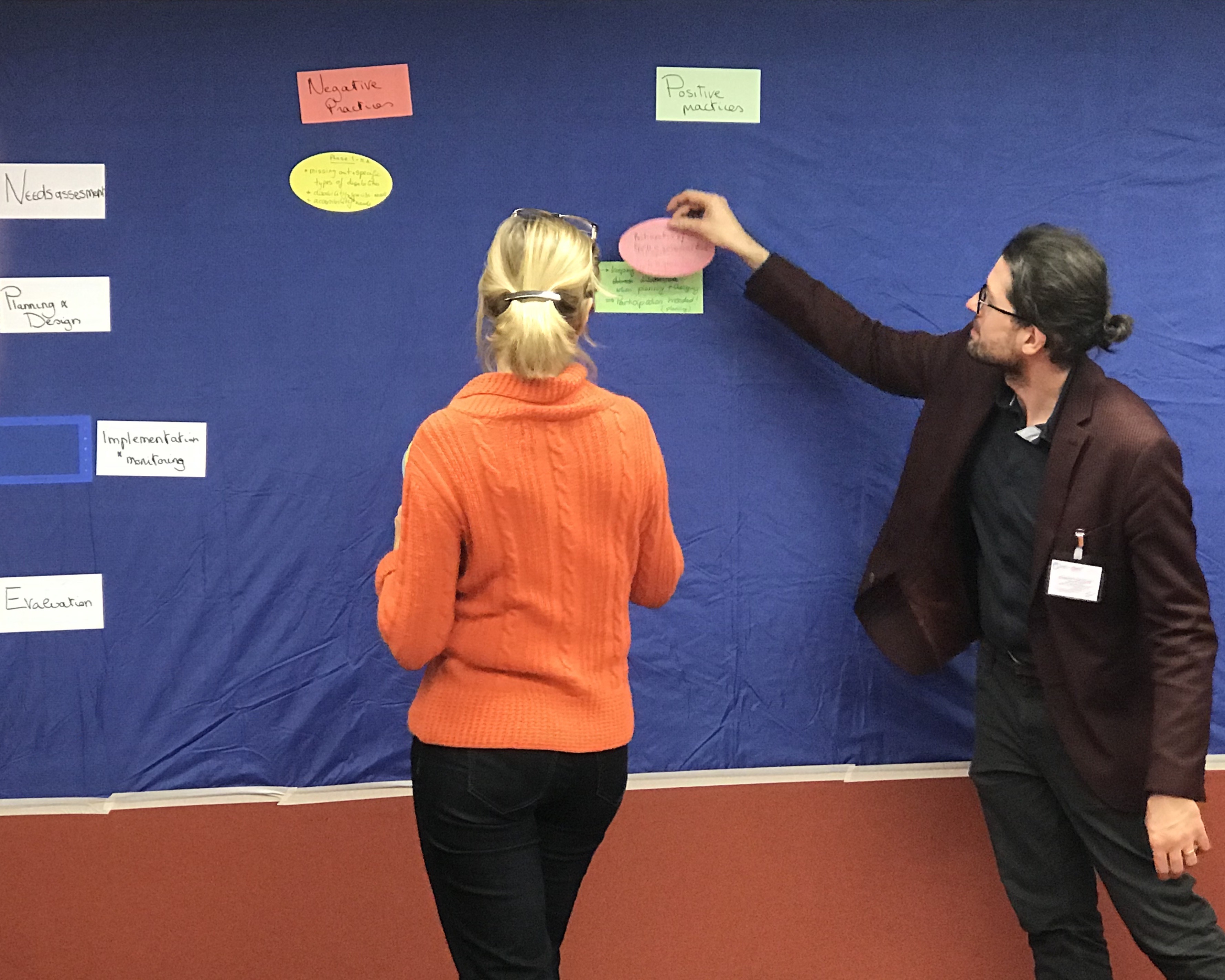 Project coordinator stands with a participant in front of a flipchart